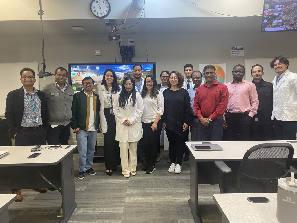 Group photo of PY1 PharmD students and faculty mentors at Larkin University College of Pharmacy after presenting mid-term research projects in a classroom setting.